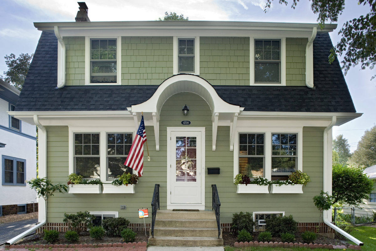 Beautiful green home with a curved arch over the front door.