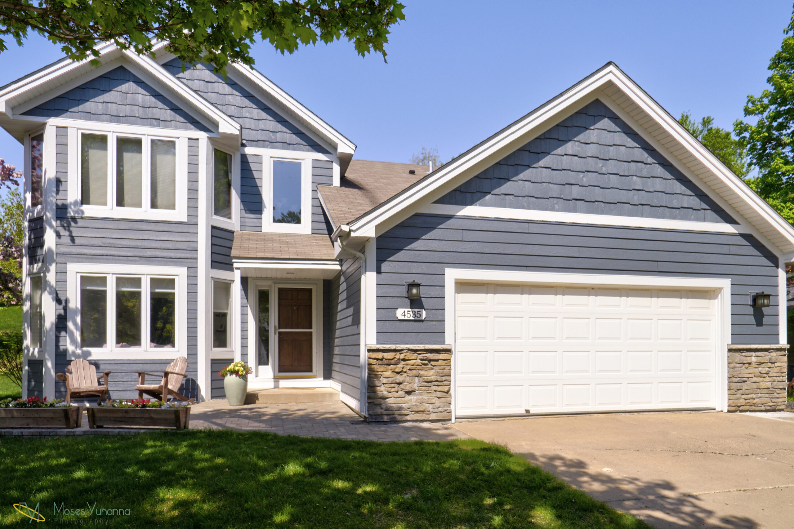 Blue house in sunshine with different types of windows