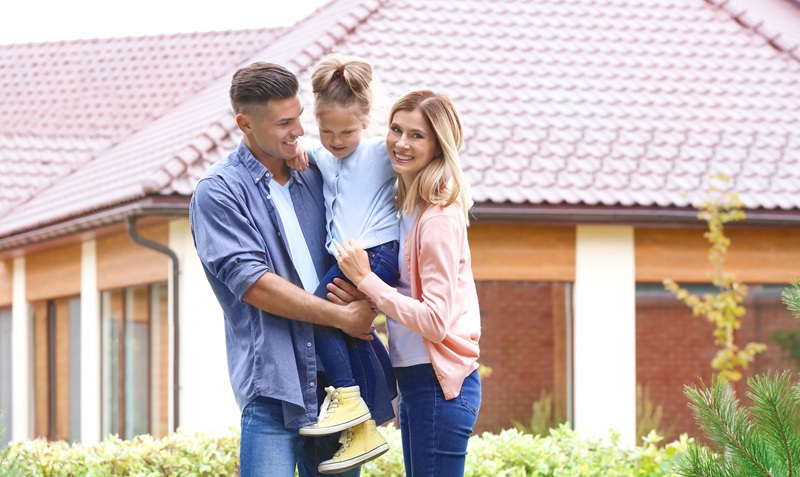Happy Family In Courtyard Near Their House