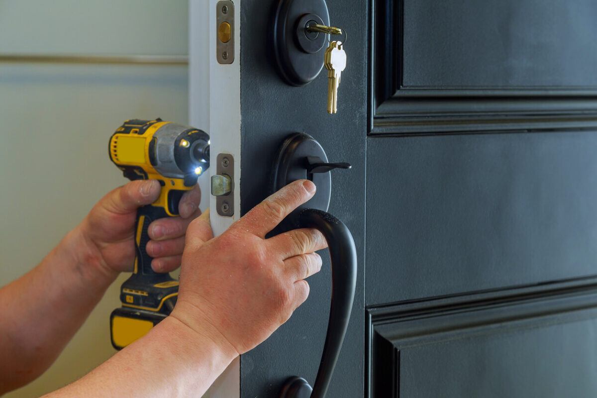 A person installing a new handle to a front door.